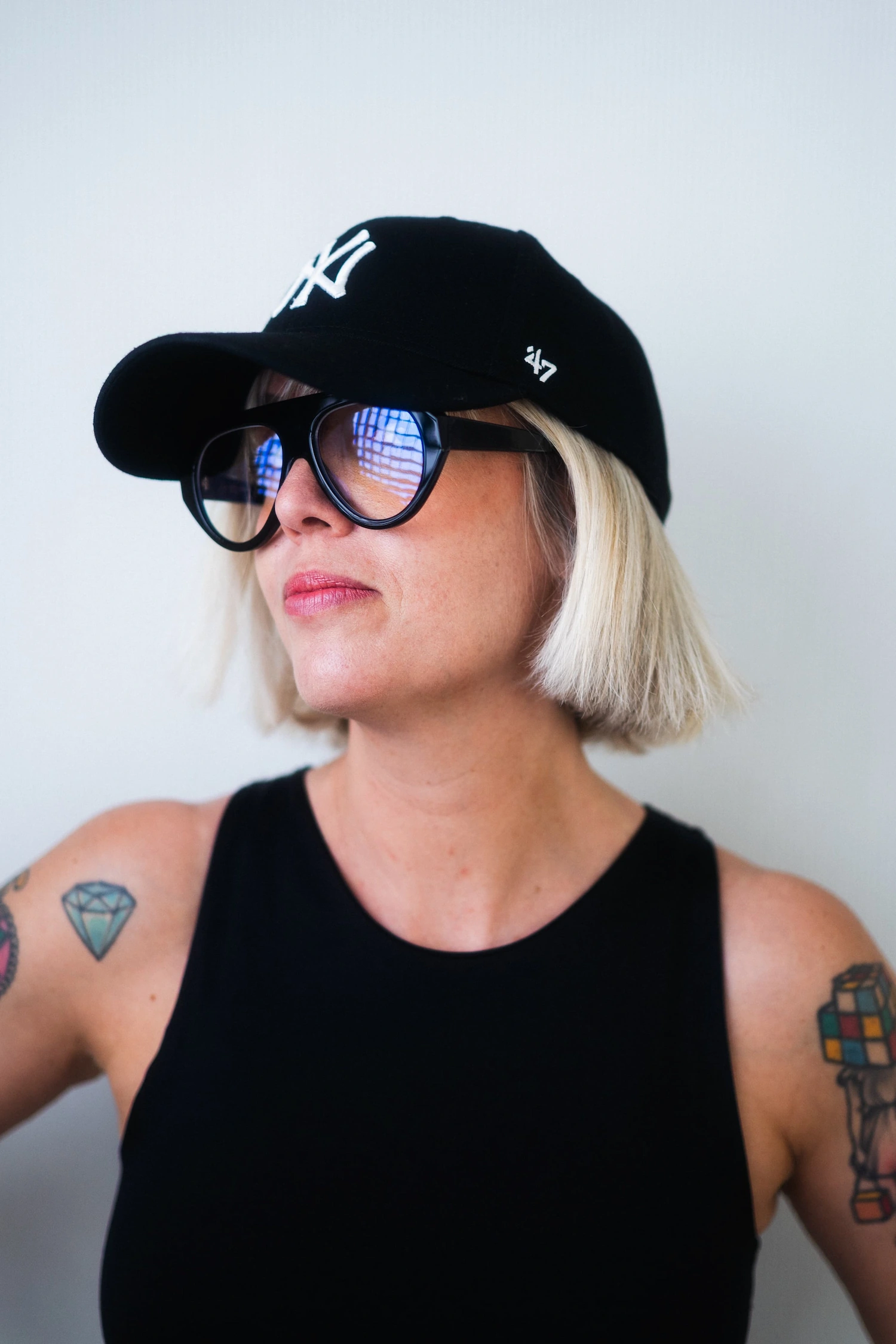 Ritratto street style con cappellino nero e grandi occhiali da vista neri spessi